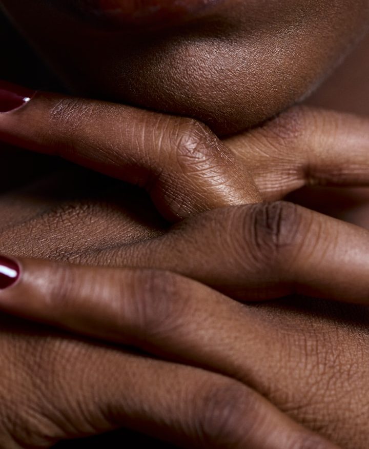 Häuserfüße eines Menschen mit dunkler Hautfarbe und Nagellack auf den Nägeln.